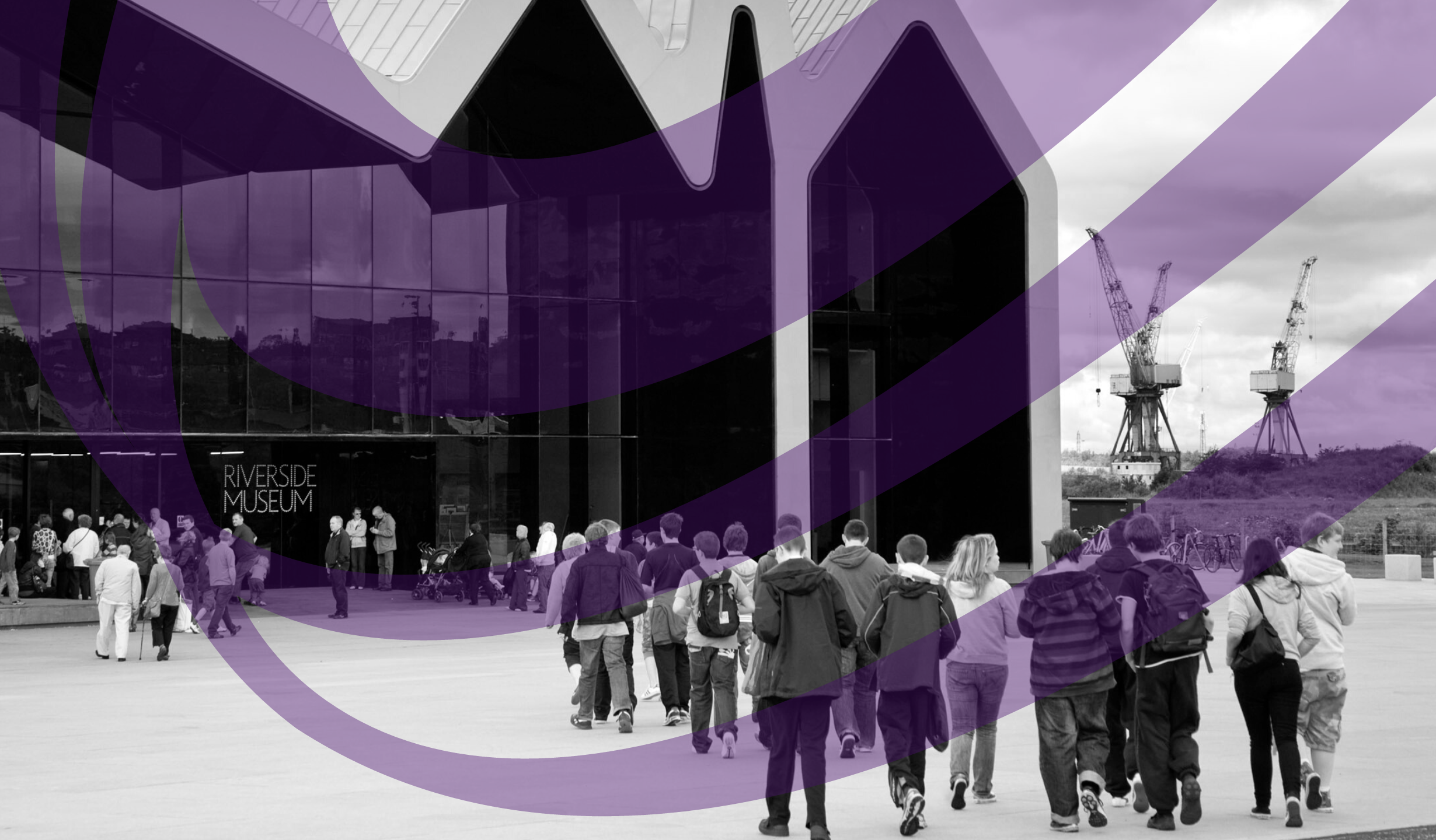 Black and white image of an older white man standing in front of a glass museum reception desk. The desk frontage says "Fairfield Heritage"
